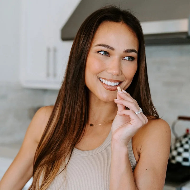 Woman taking her daily capsule in the kitchen